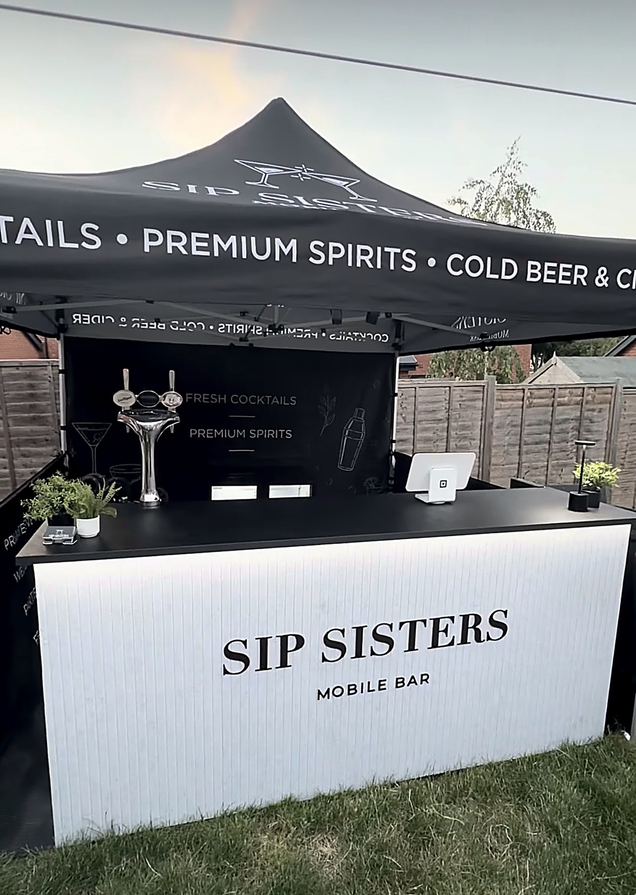 Sip Sisters pop-up bar outdoors under its branded gazebo